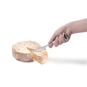 IPAC Standing Cheese Knife in use to slide a small wheel of brie cheese